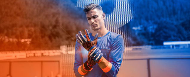 Modelo probandose unos guantes Reusch color azul con detalles de color naranja.