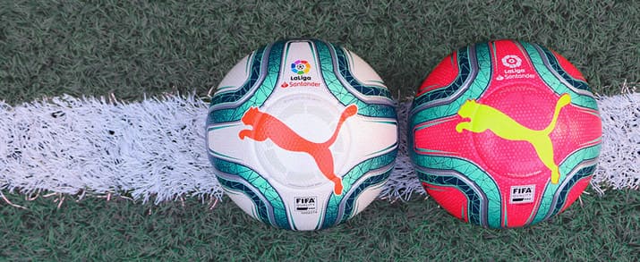 2 balones puma de La Liga Santander, el de la izquierda con un diseño que combina el color blanco con toques de azul y naranja que le dan un toque llamativo y el de la derecha una combinación de azul con fondo rosa llamativo con el logo de puma am